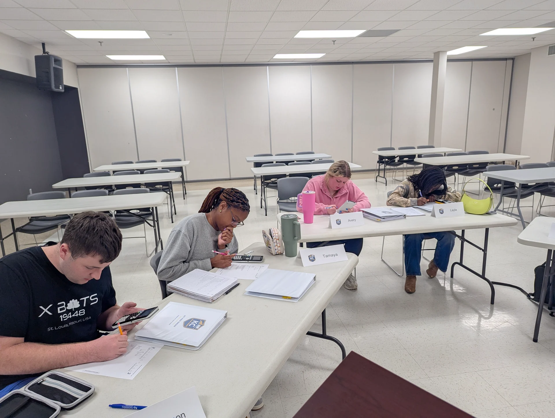 Students using calculators and course binders to work through ACT practice questions